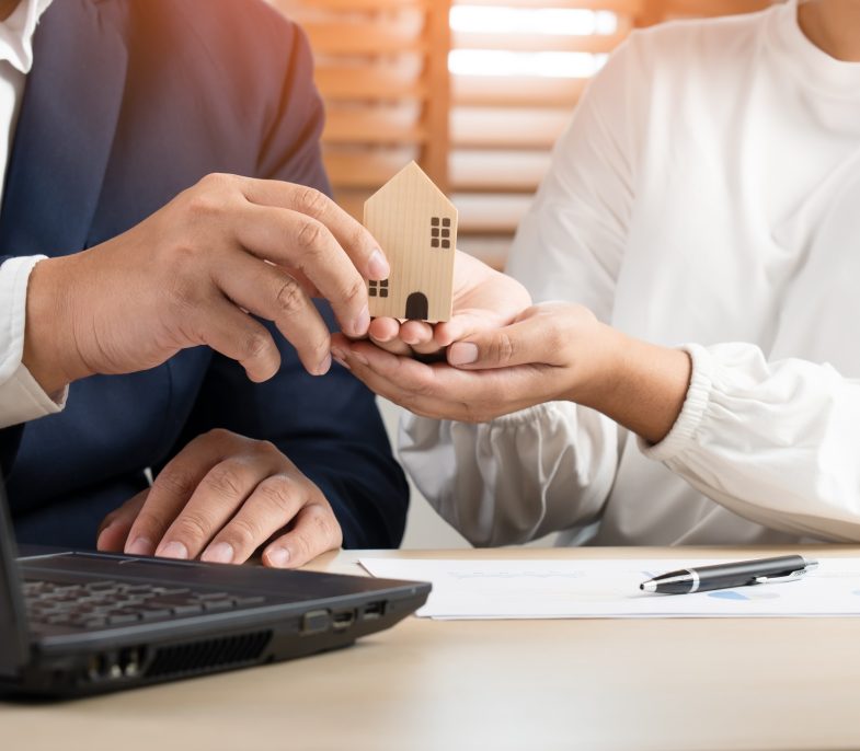 Businessman and woman to sell or buy house property as broker and client sign contract